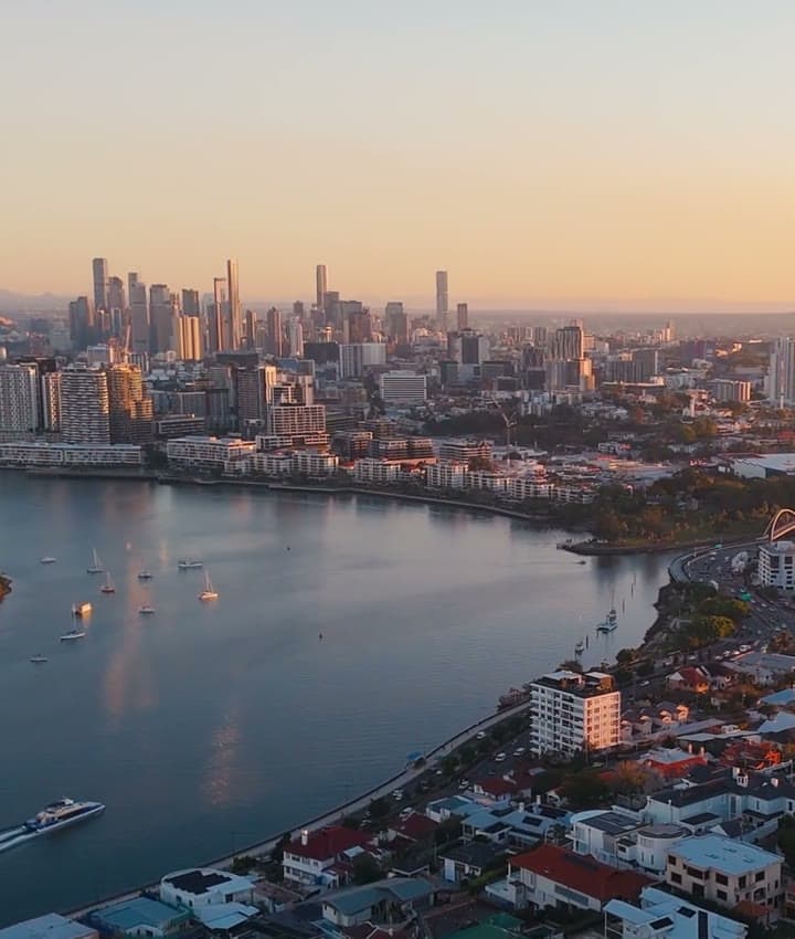 Golden-hour aerial over Hamilton and the Brisbane River towards the CBD