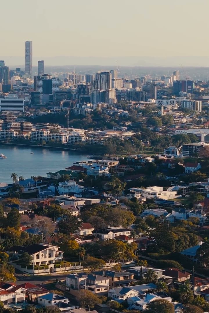 Aerial view over Brisbane rooftops to the river and the CBD skyline